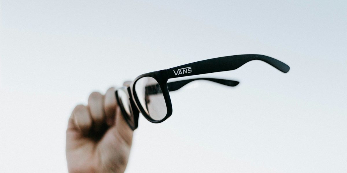 a hand holding up a pair of glasses